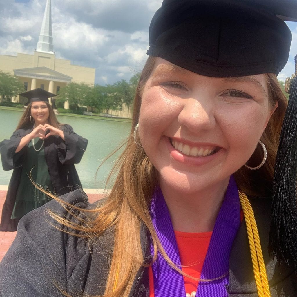 Kaitlyn Rickard and SarahBeth McKenzie share a socially distant moment on campus for diploma pick up.